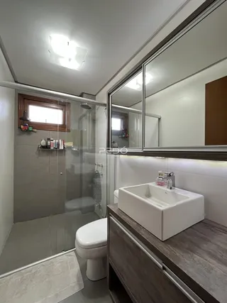 Foto de um banheiro moderno com box de vidro e bancada de madeira.