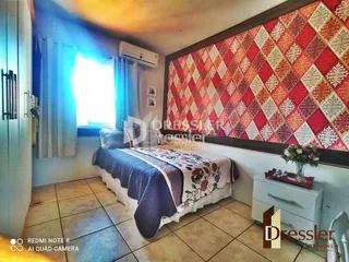 Quarto com cama e parede decorada em Lajeado.