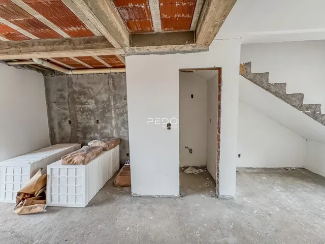 Interior de uma área em construção com paredes de concreto expostas.