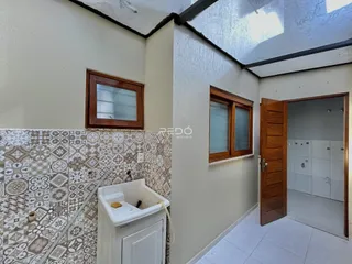 Foto de um banheiro com revestimento cerâmico e porta de madeira.