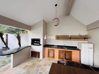 Imagem de uma área de estar e cozinha em uma residência com paredes de tijolo aparente.
