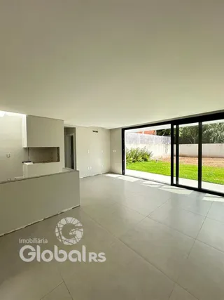 Interior de uma sala com piso de cerâmica e porta de vidro que dá para o jardim.