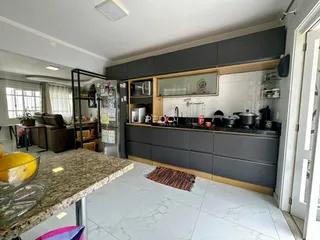 Imagem de uma cozinha moderna com armários cinzas e bancada de mármore.