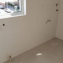 Parede interna clara com uma janela visível.