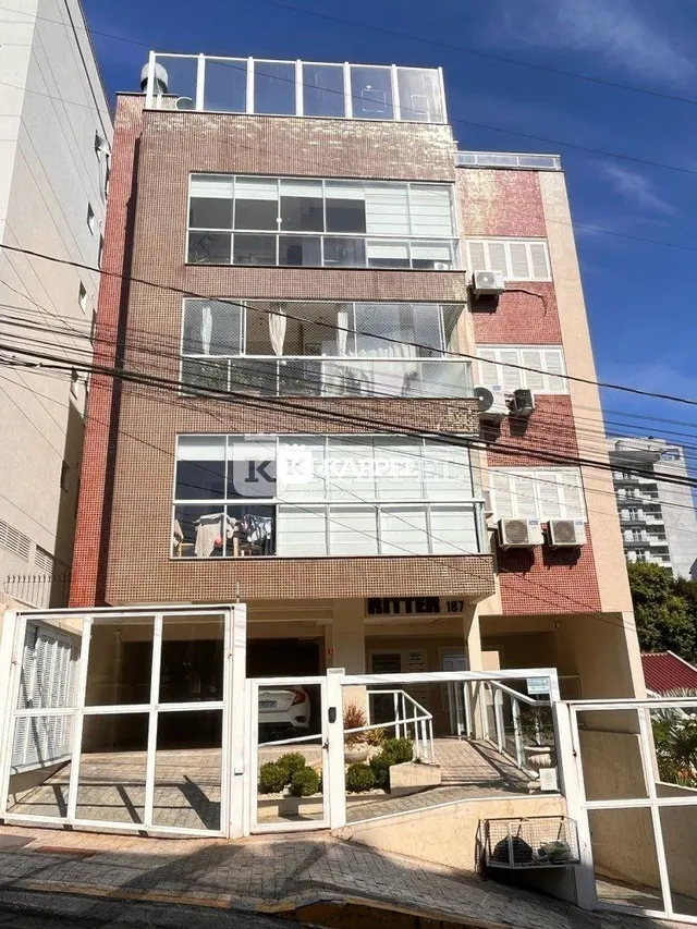 Fachada de um prédio residencial em Lajeado, Brasil, com janelas e estrutura de tijolos aparentes.