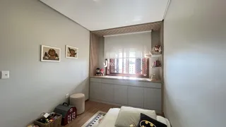 Quarto com paredes cinzas e piso de madeira.