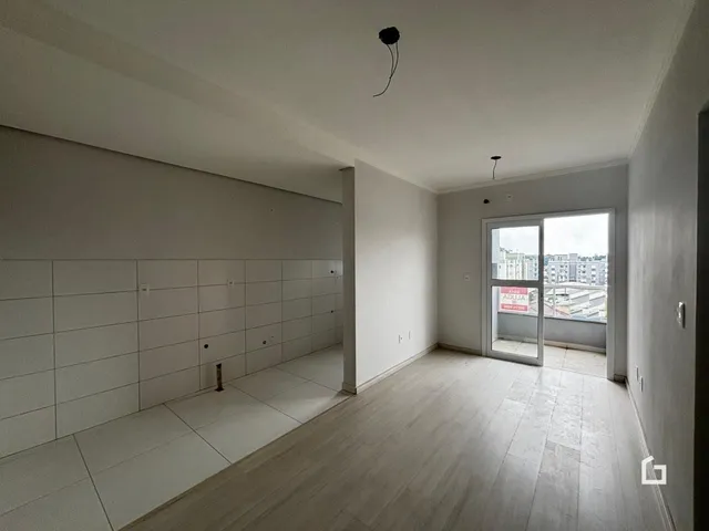 Ambiente interno de uma sala com piso de madeira clara.