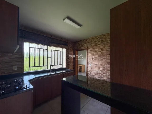 Vista da cozinha com janela e armários de madeira.