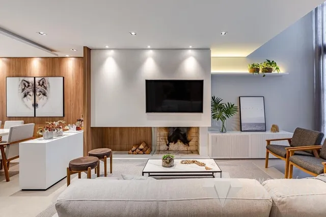 Sala de estar moderna com lareira e piso de madeira.