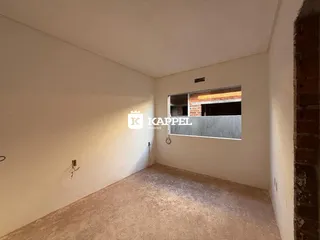 Vista interna de um cômodo com paredes brancas e piso de concreto.