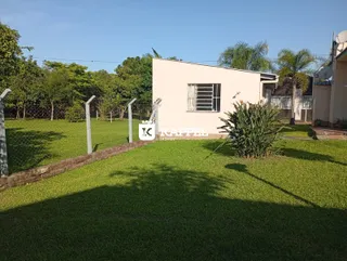 Fachada de uma casa simples com gramado verde e cerca.