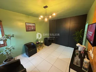 Sala de estar com paredes verdes e piso branco em um imóvel no Brasil.