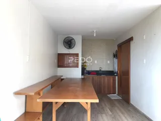 Ambiente interno com mesa de madeira e piso de madeira em uma residência.