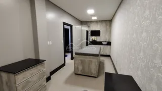 Hall de entrada com armário espelhado e televisão.