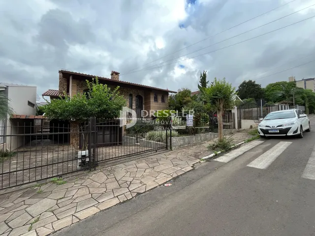 Fachada de uma residência em Lajeado, Brasil, com cerca e paisagismo na frente.