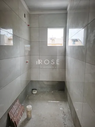 Foto de um ambiente interno com paredes cinzas e piso de concreto.