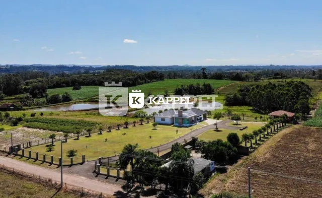 Paisagem externa mostrando campos verdes e um corpo d'água em Lajeado.
