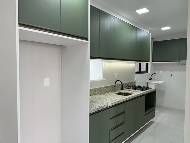 Foto de uma cozinha moderna com armários verdes e bancada de granito.