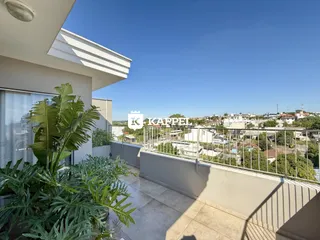 Vista panorâmica da área externa do apartamento em Lajeado, com vegetação exuberante.