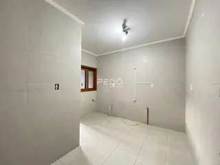 Hall de entrada com paredes brancas e piso de cerâmica.