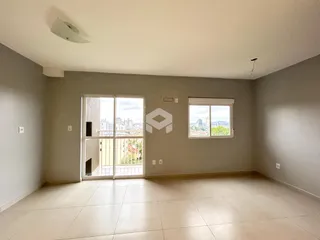 Sala de estar com piso claro e grandes portas de vidro voltadas para a vista da cidade.