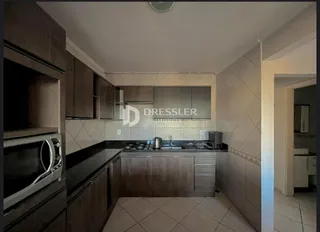 Foto de uma cozinha com armários de madeira e bancadas escuras.