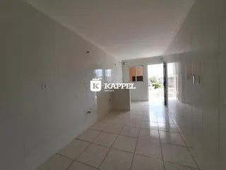 Foto de um corredor interno de uma residência com piso de cerâmica clara.