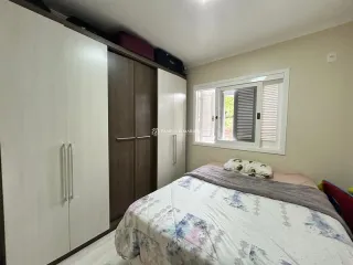Quarto com cama e armários brancos em um imóvel.