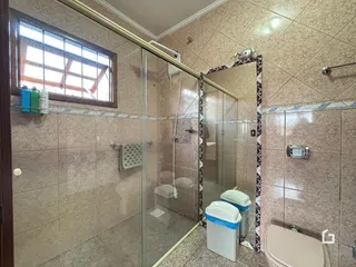 Foto de um banheiro com box de vidro e azulejos na Lajeado.