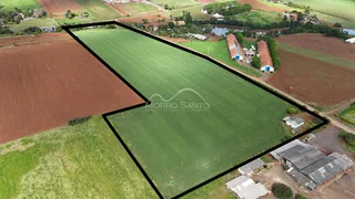Vista aérea de uma propriedade rural com campos cultivados e estruturas rurais.