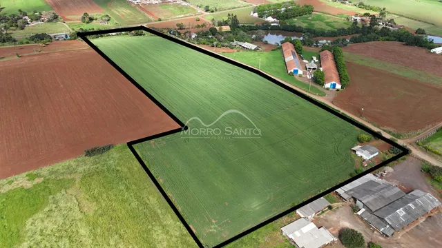 Vista aérea de uma propriedade rural com campos cultivados e estruturas rurais.