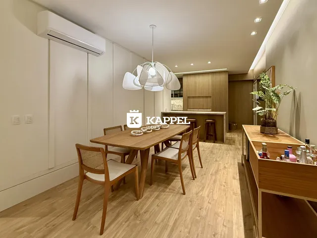 Foto de um ambiente de jantar com mesa de madeira e piso claro.