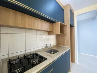 Cozinha moderna com armários azuis e bancada clara.