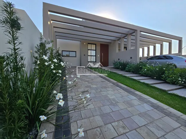 Fachada de uma casa moderna com jardim e calçada em Lajeado.