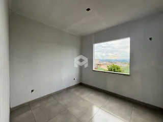Foto de um cômodo interno com piso de cerâmica e uma grande janela.