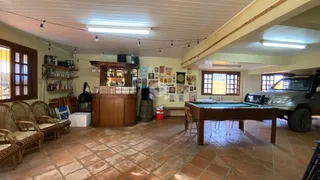 Foto de uma área comum interna com piso de cerâmica e móveis de madeira.