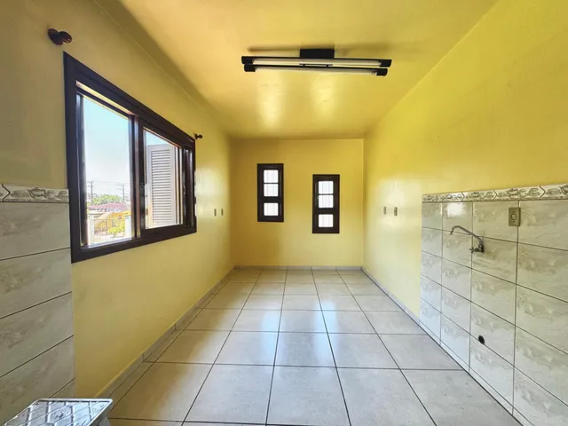 Hall de corredor com paredes amarelas e piso de cerâmica.