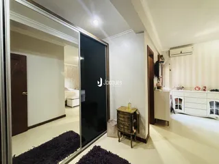 Hall de entrada com espelho refletindo um quarto.