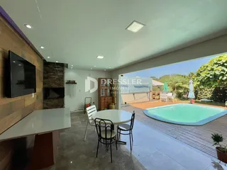 Sala de estar com vista para um pátio e piscina no quintal.