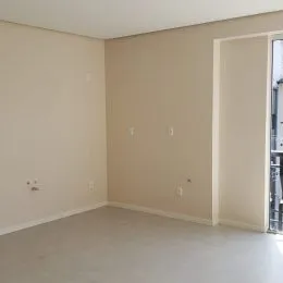Foto de um cômodo interno vazio com paredes claras.