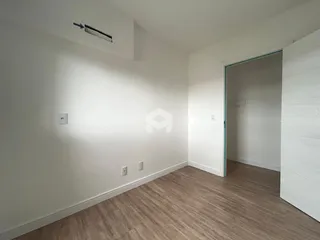 Imagem de um ambiente interno com piso de madeira clara e paredes brancas.
