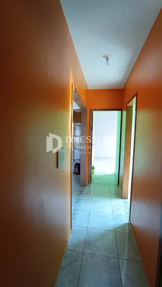 Corredor interno com paredes alaranjadas e piso de cerâmica.