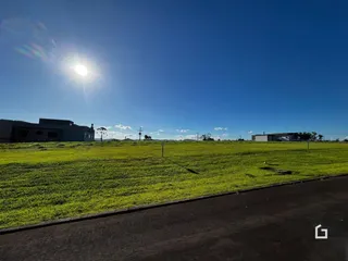 Campo gramado com edifícios ao fundo.
