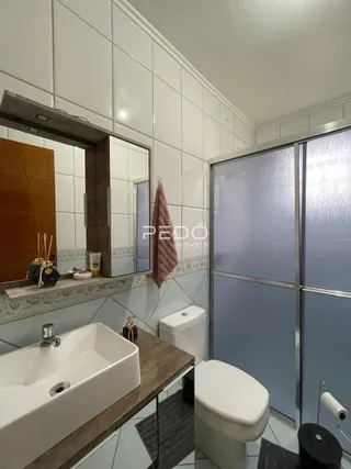 Foto de um banheiro com azulejos brancos e box de vidro.
