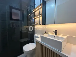 Banheiro moderno com bancada branca e revestimento de madeira.