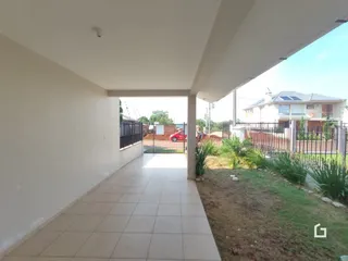 Corredor interno de uma residência com piso de cerâmica e acesso ao jardim.