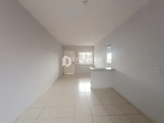 Vista do corredor interno de uma residência com piso de cerâmica.