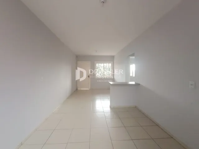 Vista do corredor interno de uma residência com piso de cerâmica.