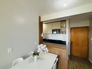 Ambiente interno com parede branca e móveis de madeira em uma sala de jantar.