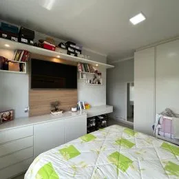 Foto de um quarto com cama e paredes brancas.